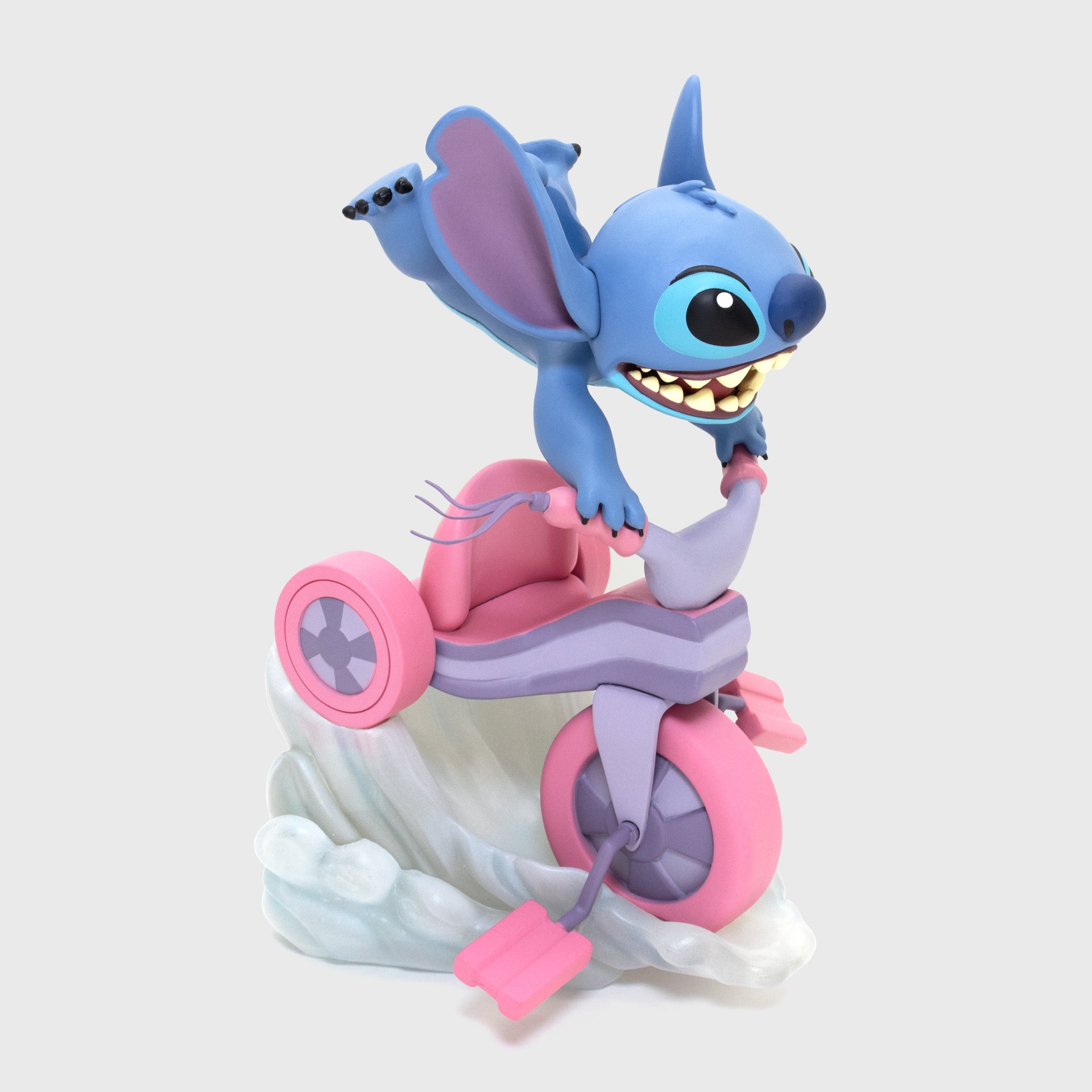 stitch riding on tricycle facing sideways. stitch grabbing handlebars while body is up in air. tricycle on fast air.