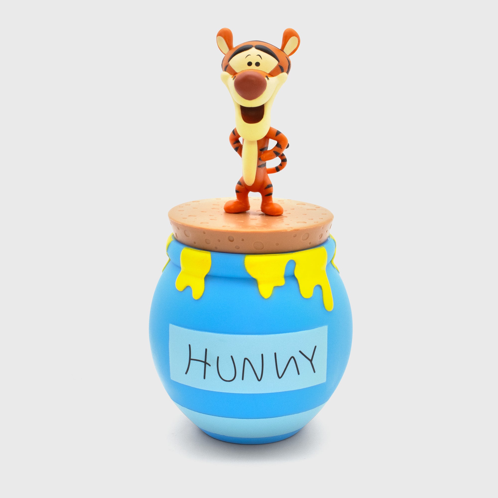 tigger standing with hands on hips and ears up on top of hunny pot