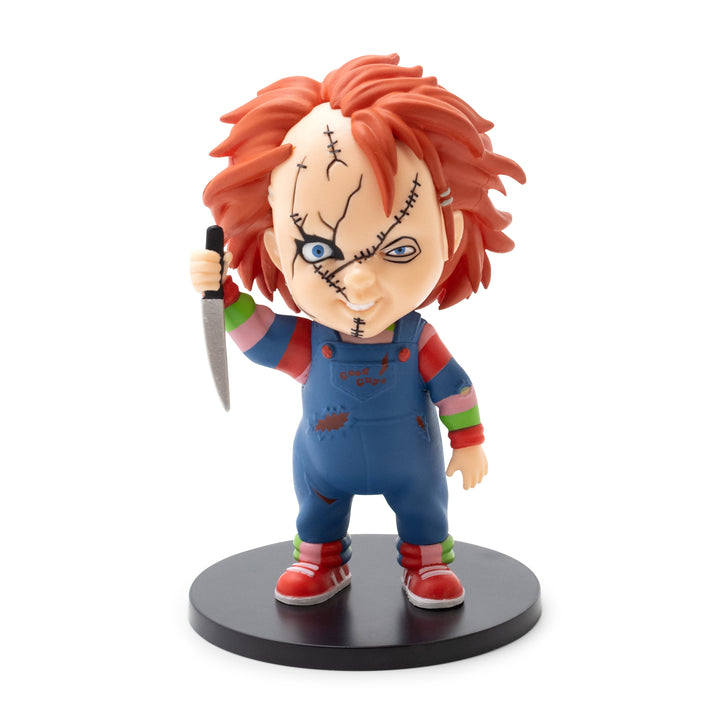 Toy figure of a character with red hair and blue eyes, holding a knife, on a white background.