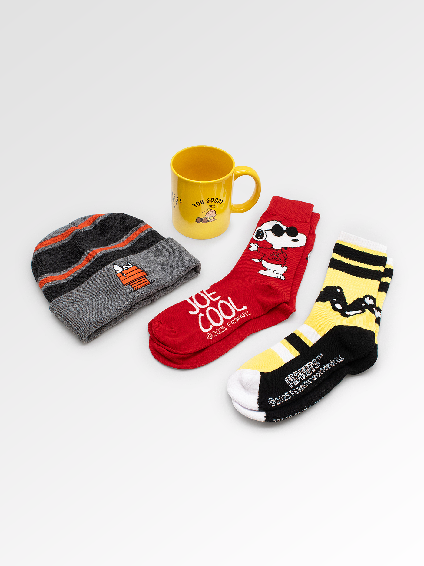 Set of socks, beanie, and mug with cartoon designs on a light gray background
