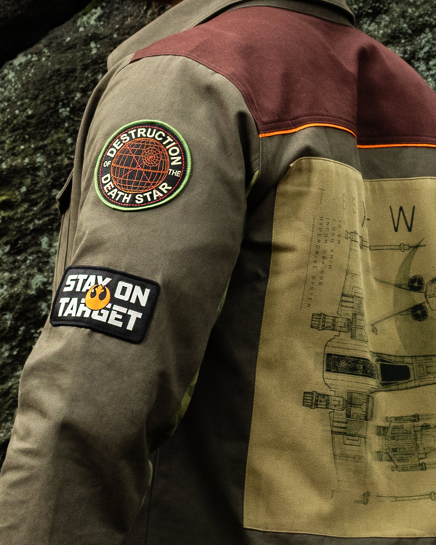 Close-up of a jacket with patches and designs, including a Star Wars-themed patch.
