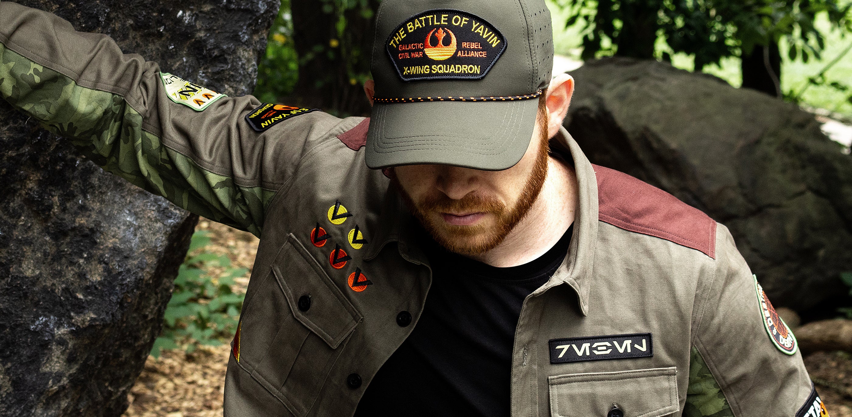 Man wearing a Star Wars-themed cap and jacket in a forest setting