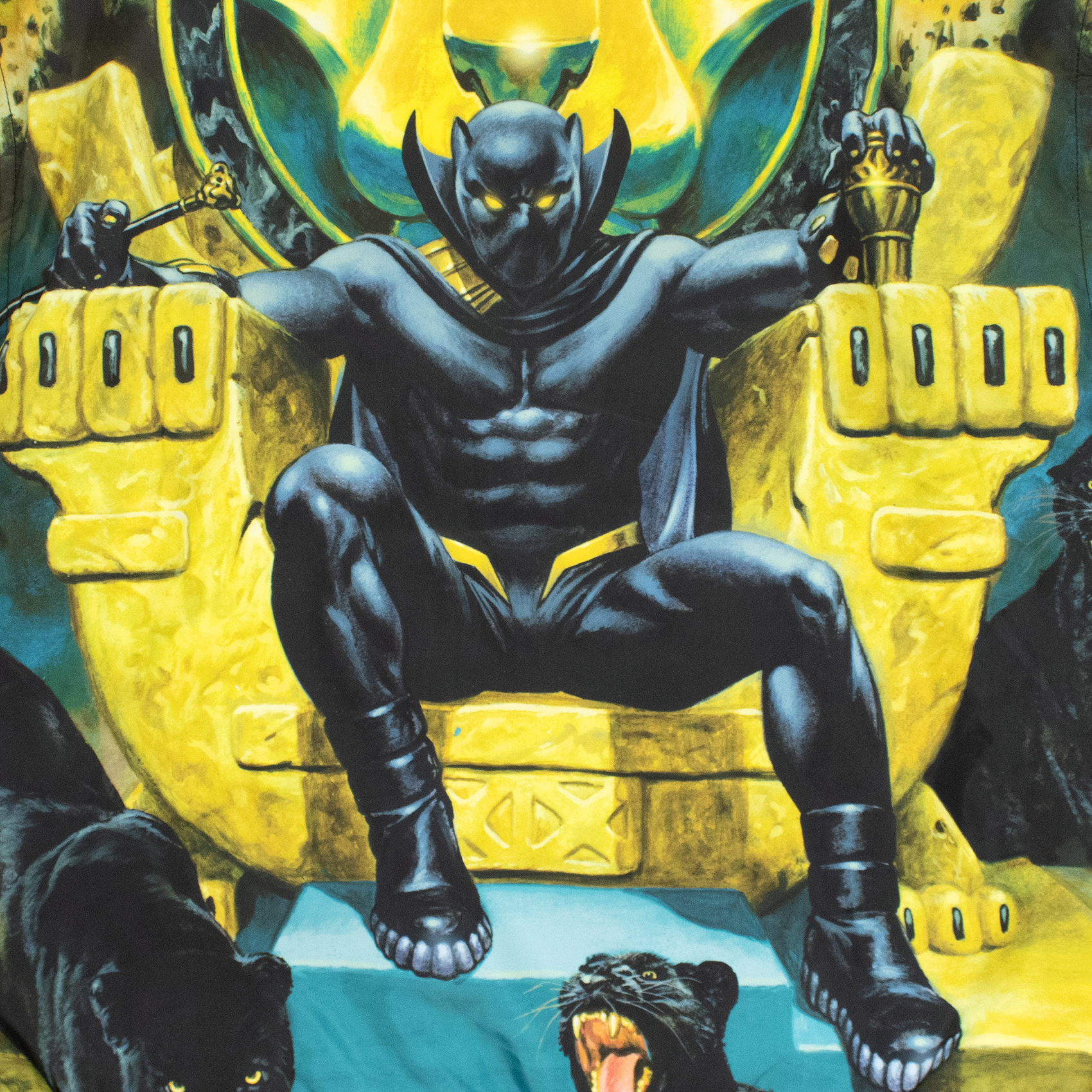 close up image on front: black panther sitting on yellow throne. two real panthers laying down below him.