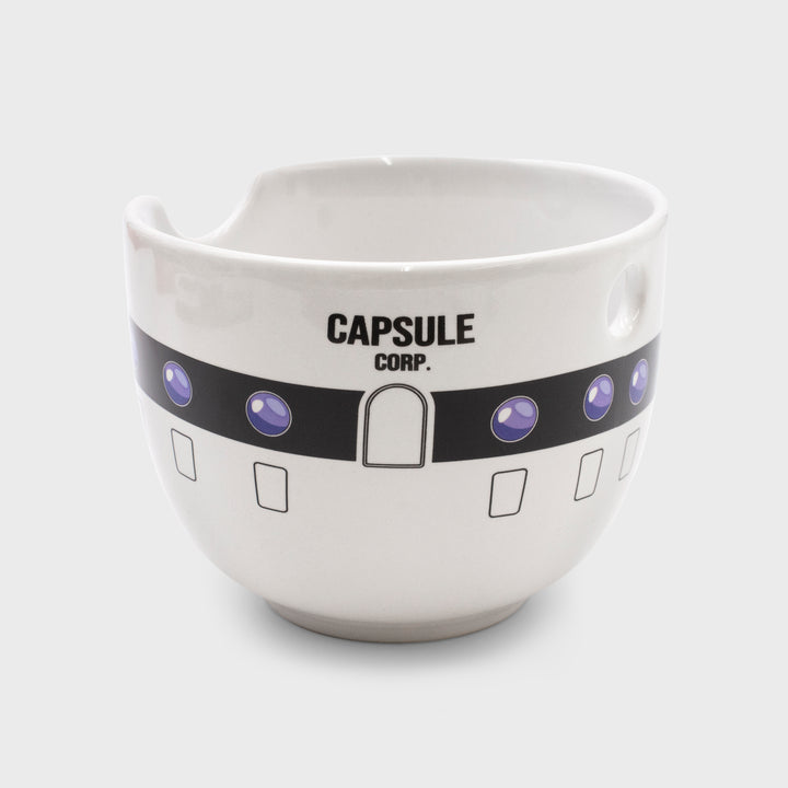 ramen bowl. looks like capsule corp building. text says capsule corp. has holes to hold and rest chopsticks