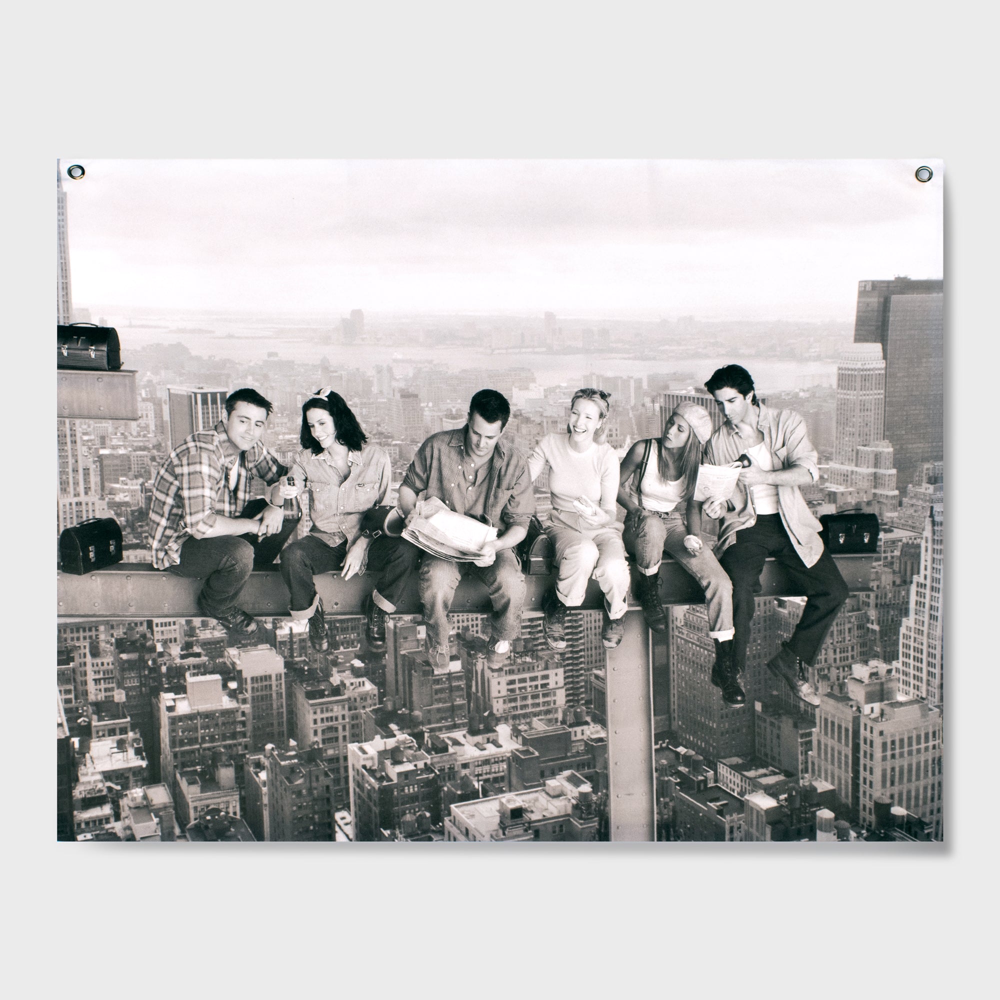 black and white wall tapestry. shows full friends cast sitting on a building beam over manhattan. from left to right: joey, monica, chandler, phoebe, rachel, ross.