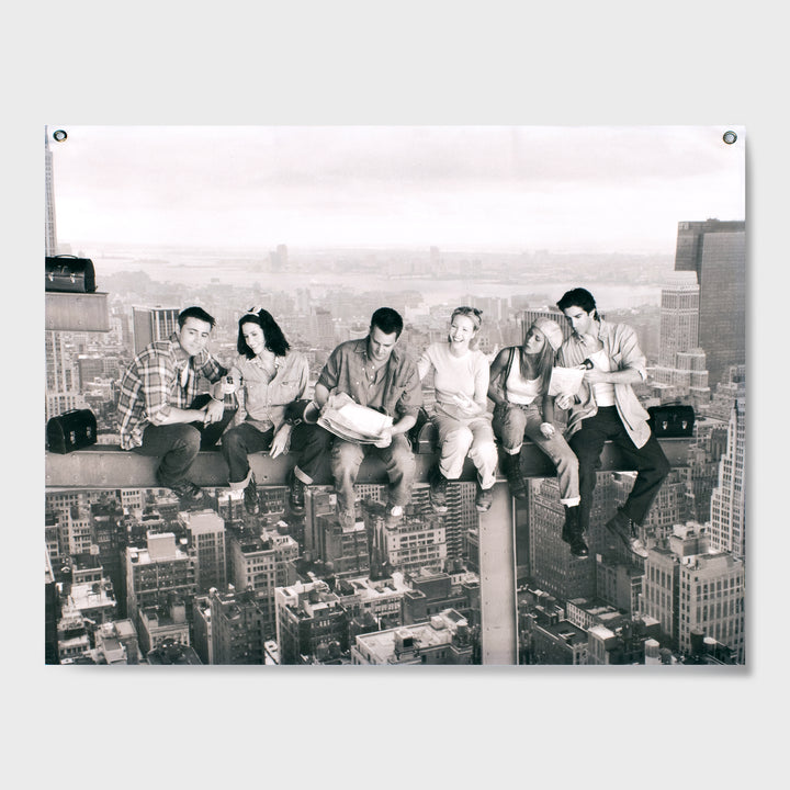 black and white wall tapestry. shows full friends cast sitting on a building beam over manhattan. from left to right: joey, monica, chandler, phoebe, rachel, ross.
