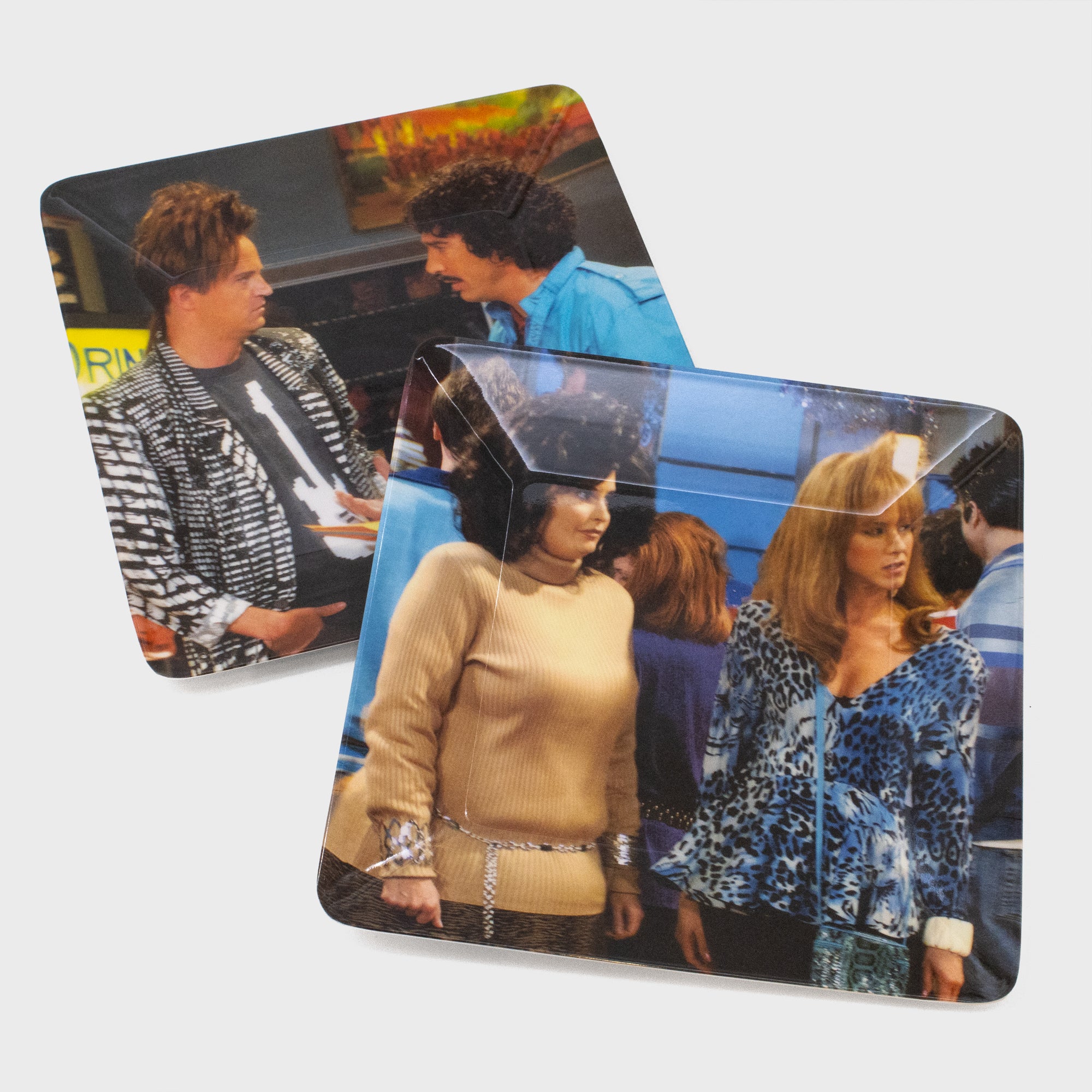 a pair of melamine plates. 1 features ross and chandler from the 80s. the other has rachel and monica from the 80s. 