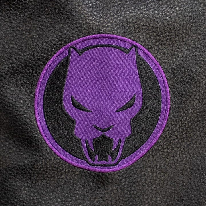 close up of patch on sleeve. purple black panther emblem.
