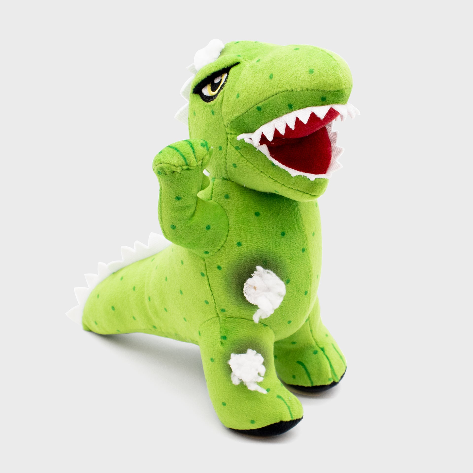 dinosaur plush. fake stuffing coming out of belly and leg.